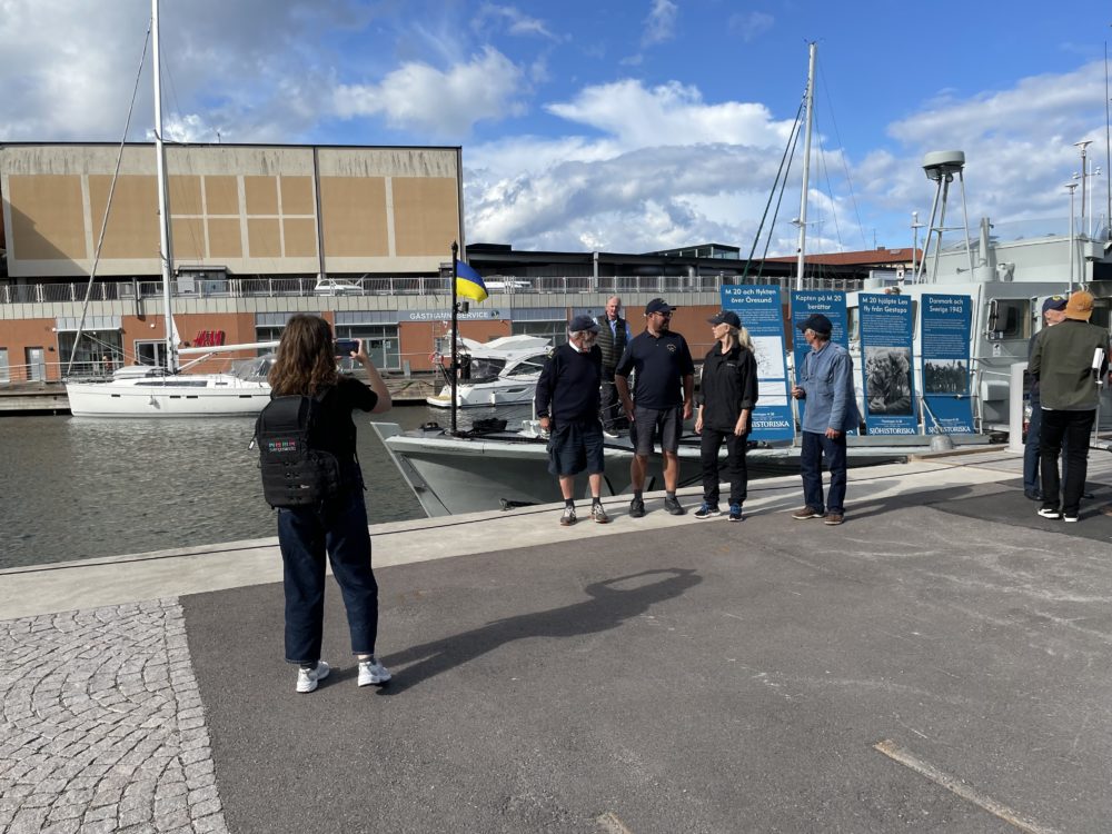 black and white sailboat in body of water during sunset