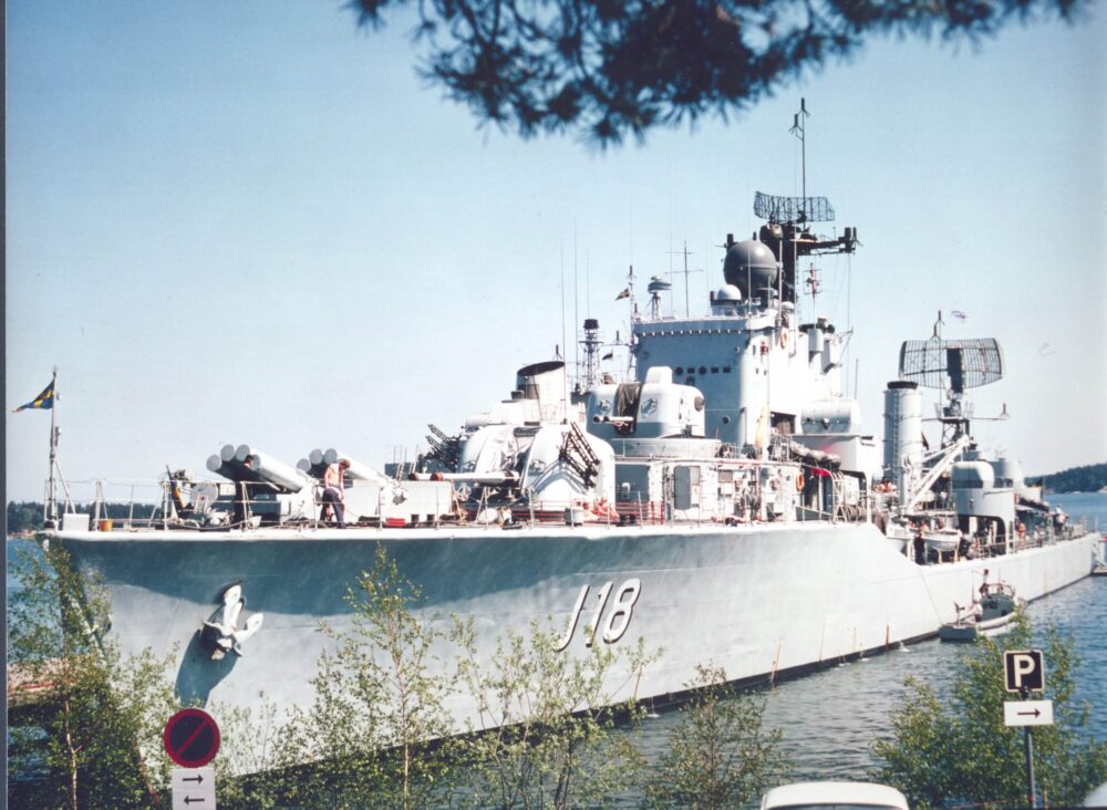 black and white sailboat in body of water during sunset